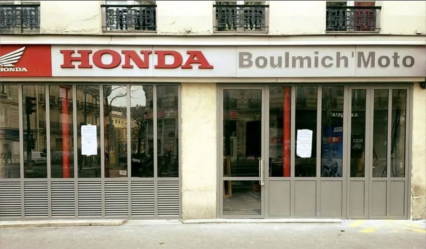 Façade de la concession Honda Boulmich'Moto, boulevard Saint-Michel à Paris : vitrines en profilés acier thermolaqués, grilles de ventilation en soubassement.